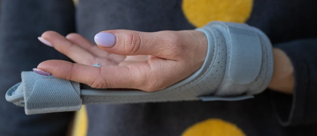 Photo of a hand wearing a finger brace to illustrate how immobilisation leads to weakness and reduced coordination